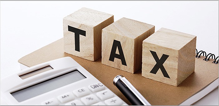 letters taxes on wooden blocks with calculator and pen