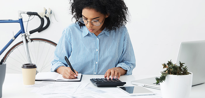 8 Things Real Estate Experts Won’t Tell You About Hard Money 4 businesswoman doing paperwork at office desk, working through finances, using calculator and making notes in her notebook with pen