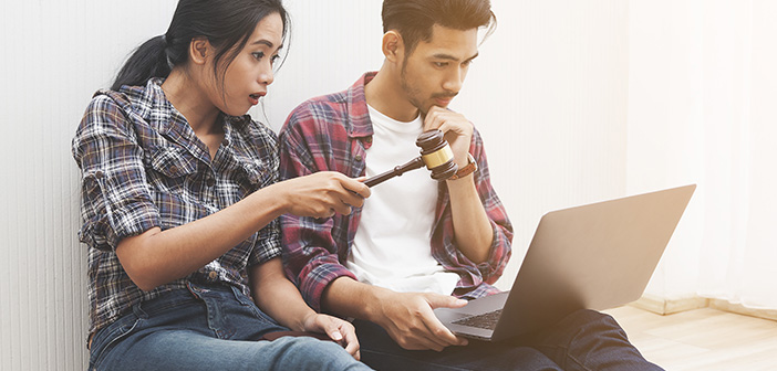 couple on laptop, on holding gavel, online auction concept