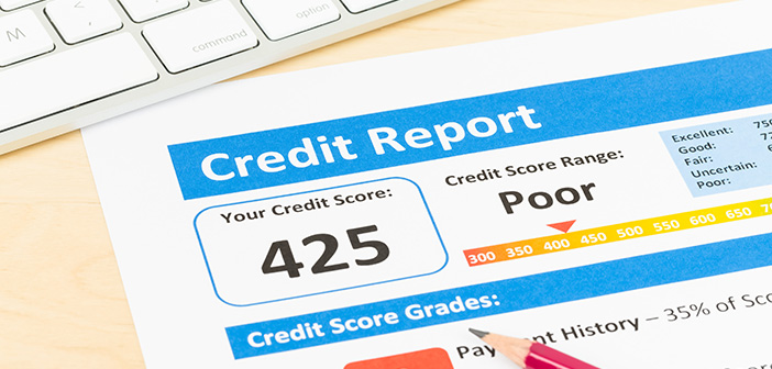 Poor credit score report with pen and keyboard