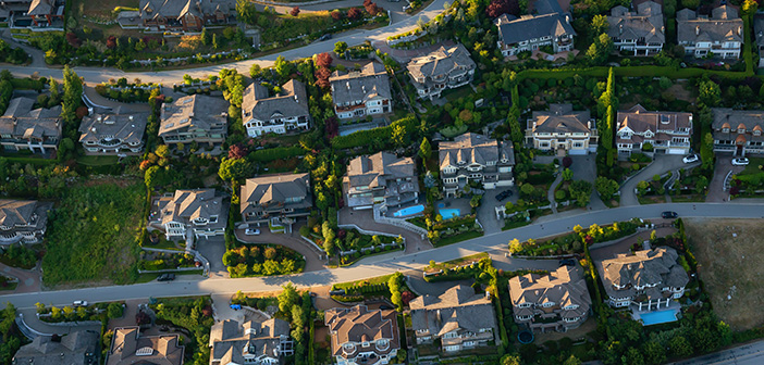 Aerial view of the big luxury homes on the hill during a vibrant sunny summer day.