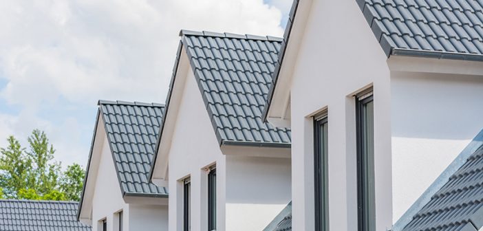close up view of upper level windows and roofs on four row homes