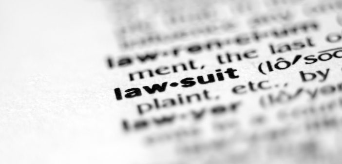 Extreme macro or close up of the word LAW-SUIT. Very shallow depth of field is intentional and shows only the word LAW-SUIT in focus.